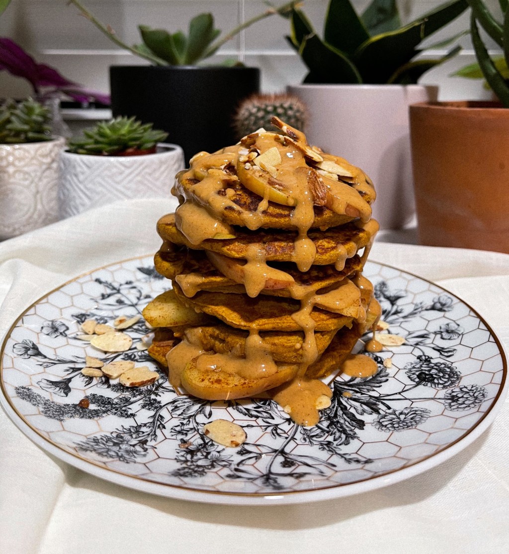 mouth watering stack of snickerdoodle pancakes with sauteed cinnamon honeycrisp apple slices and a sweet pb drizzle